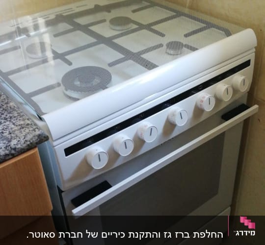 תנור גז עם כפתורים לבנים במטבח